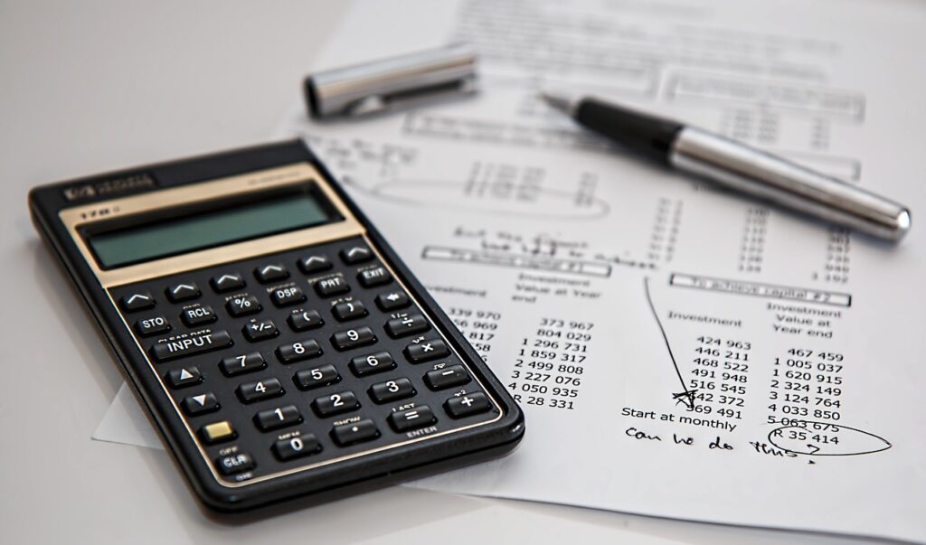 a calculator and pen on a piece of PAPER