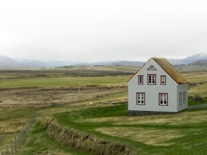 a blue house in the green countryside on its own with no other buildings
